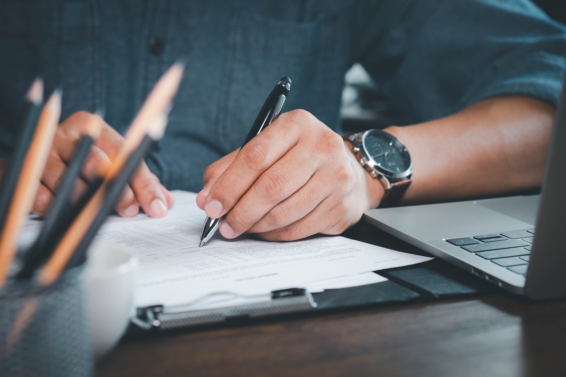 Close-up of Hand using writing pen with questionnaire